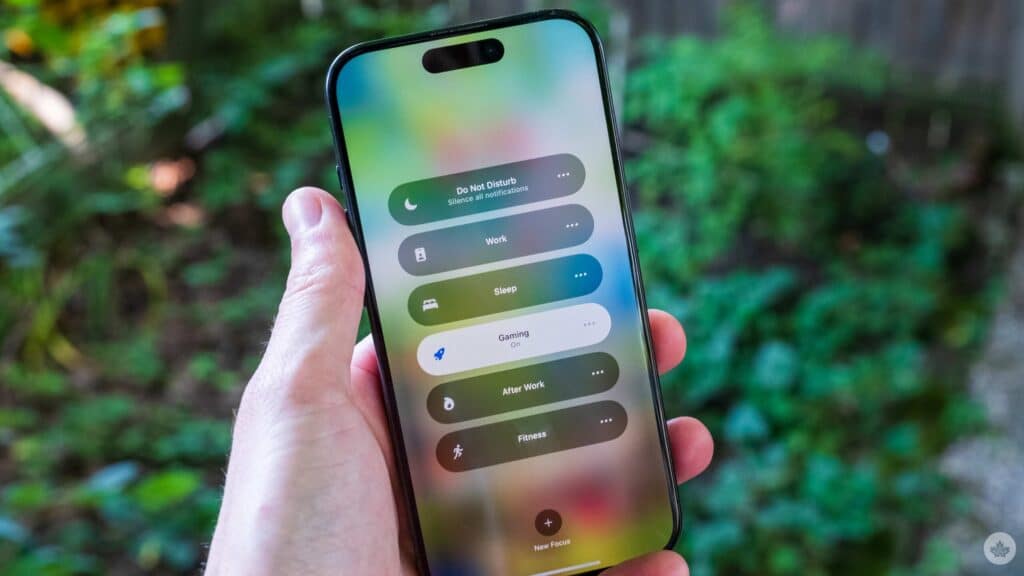 a hand holding an i phone and showcasing custom focus feature ios 26