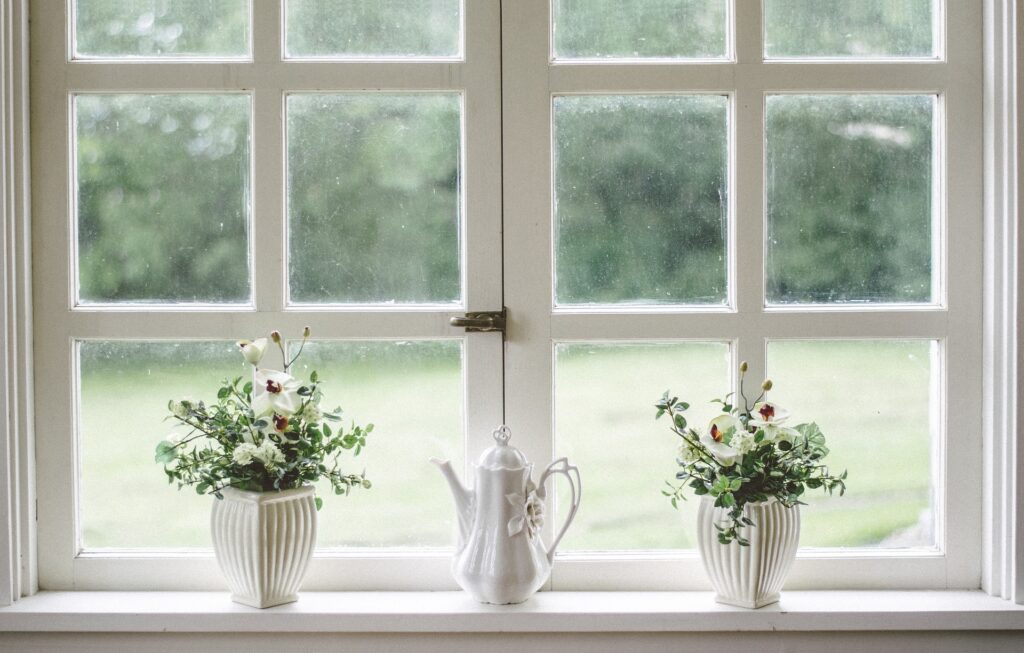 an image of artificial flower near window, fake flowers
