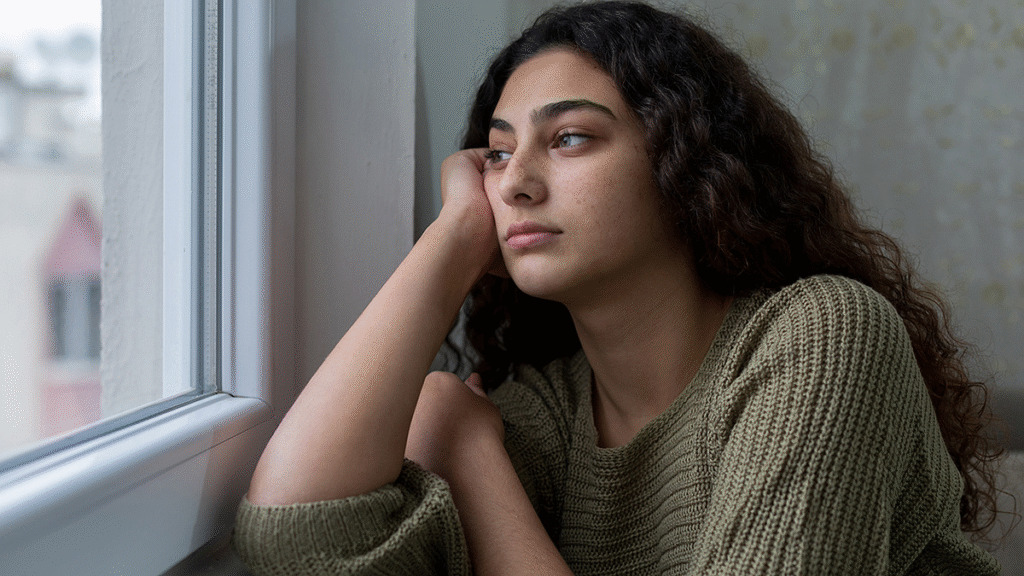 a girl siting alone near window