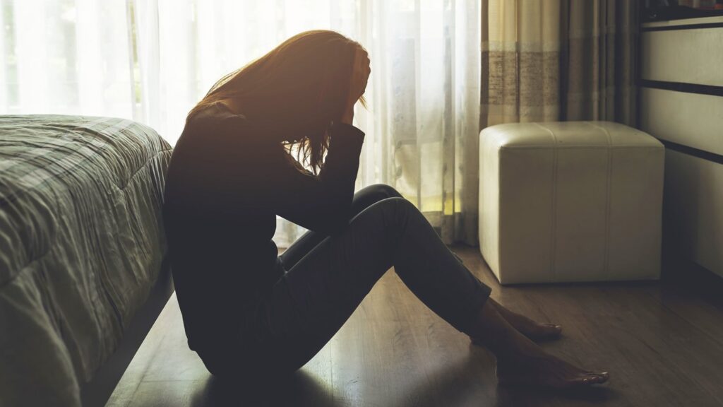 a girl sitting on the floor suffering with seasonal depression